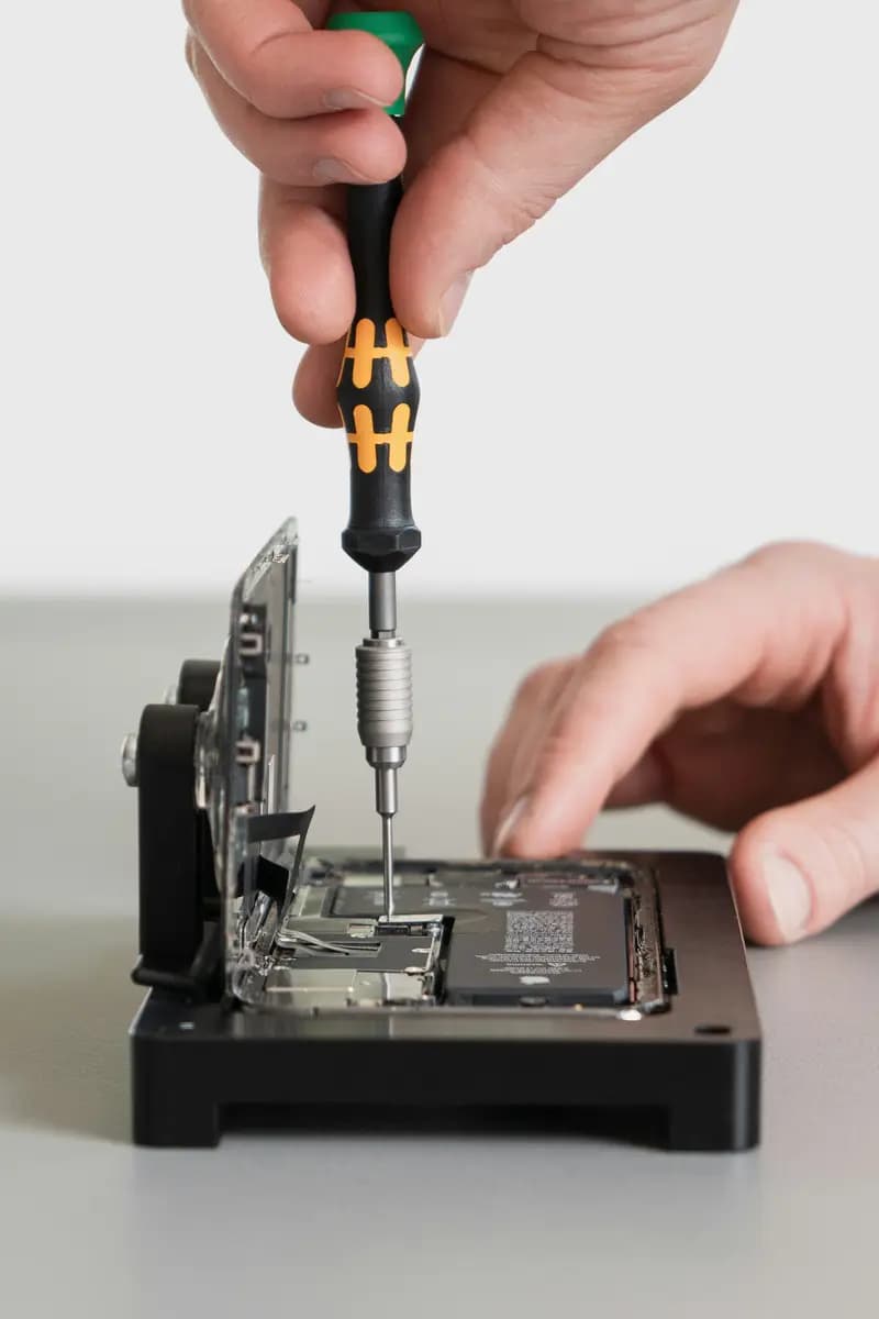 Technician using a precision screwdriver on a phone